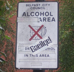 Protestní nálepka na ceduli zákazu alkoholu v centru Belfastu